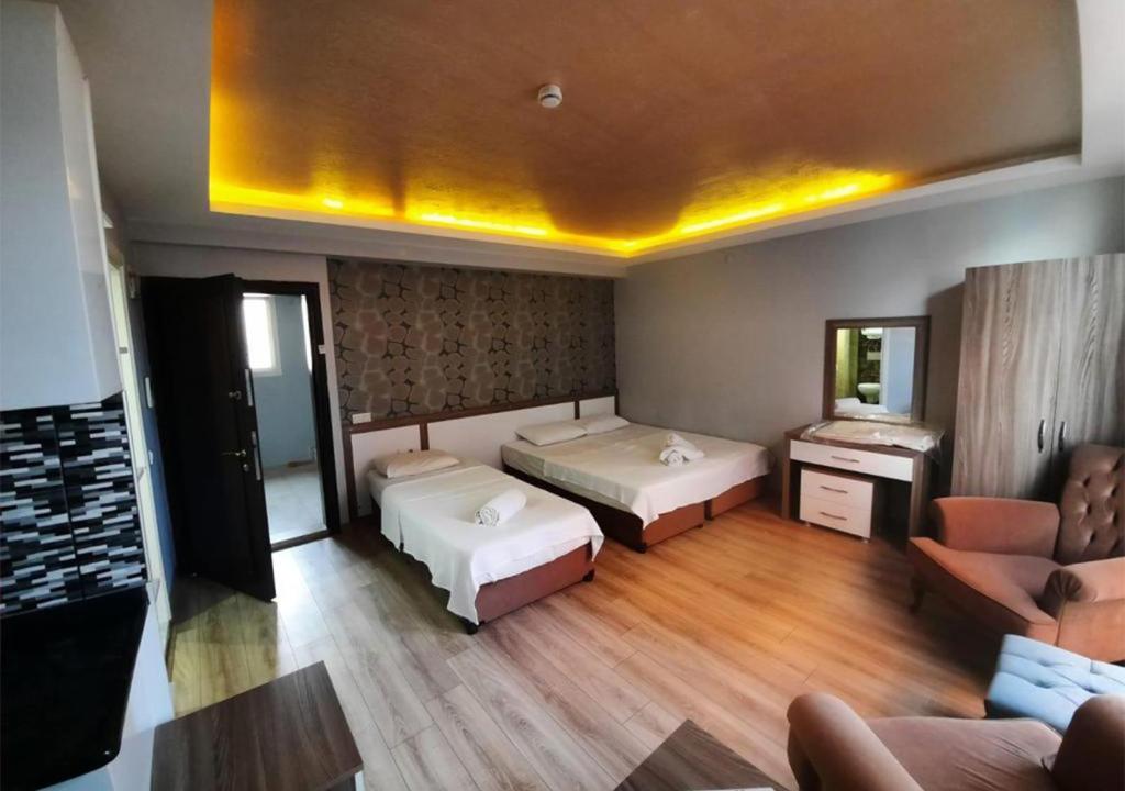 een grote kamer met 2 bedden en een bank bij Kuşadası Apart Dairelerimiz in Kuşadası
