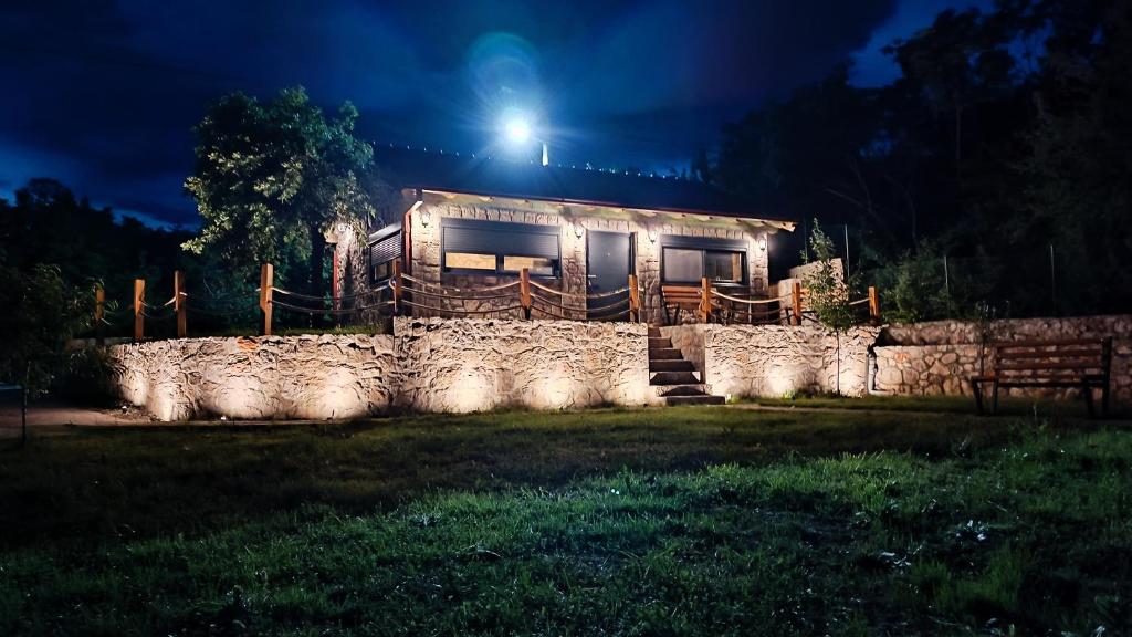 een huis met een licht op een stenen muur bij Stone House Montenegro in Danilovgrad