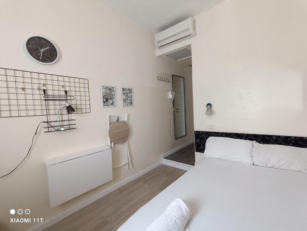 1 dormitorio con 1 cama y reloj en la pared en Private rooms near the beach center en Tel Aviv