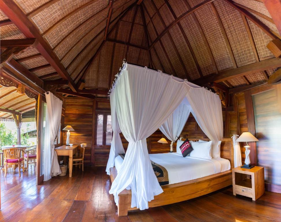 a bedroom with a canopy bed in a resort at Villa Neyang in Ubud
