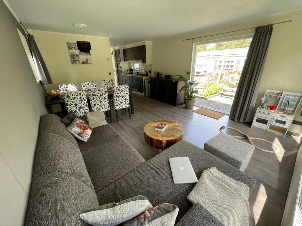 een woonkamer met een bank en een tafel bij Forest Family 6 persoons op 5 sterren park in Beekbergen