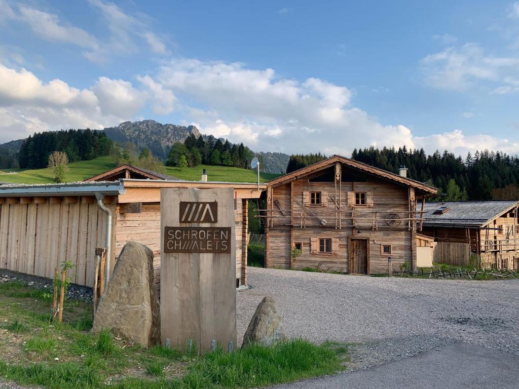 a sign in front of a wooden building at Schrofen Chalets in Jungholz