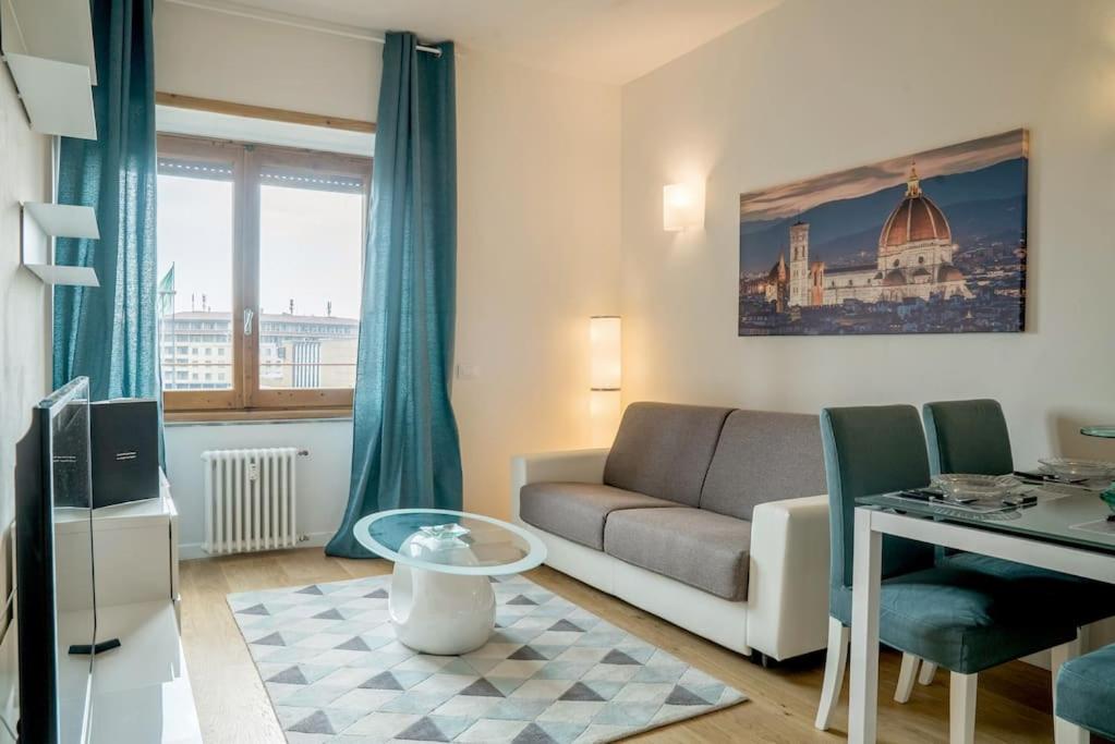 ein Wohnzimmer mit einem Sofa und einem Tisch in der Unterkunft Alinari Boutique Apartments in Florenz