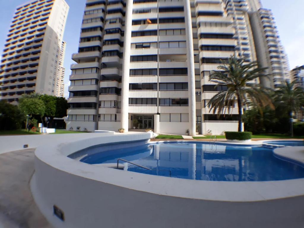 uma piscina em frente a um edifício alto em Apartamento Torre Europa em Benidorm