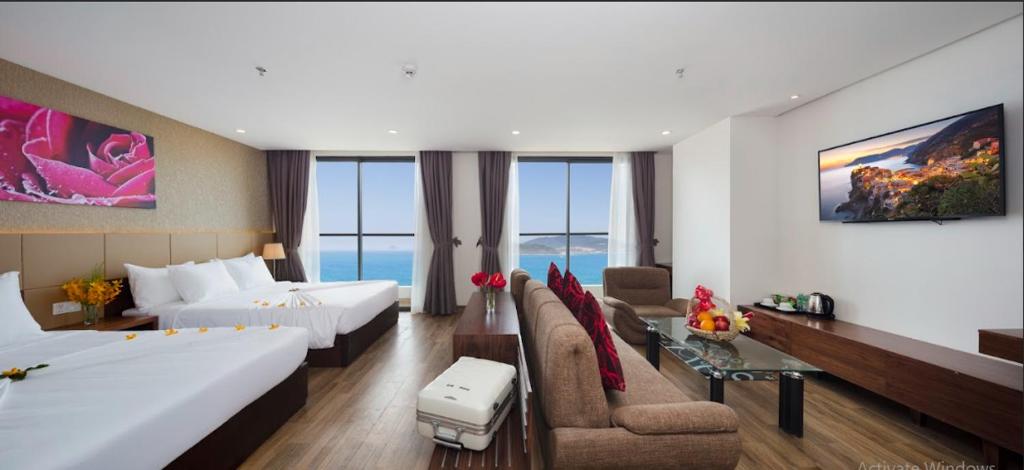 ein Hotelzimmer mit 2 Betten und einem Sofa in der Unterkunft Sea Pearl Hotel in Nha Trang
