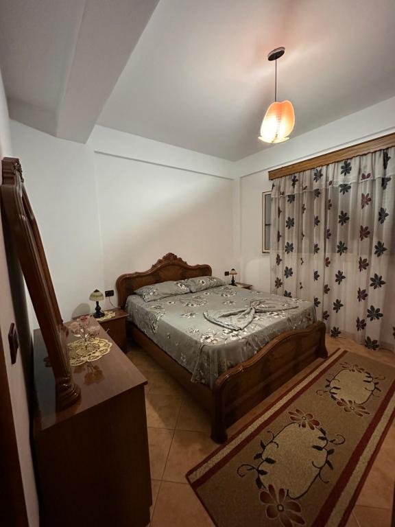 a bedroom with a bed and a dresser and a table at Vila Adriatik 1 in Vlorë