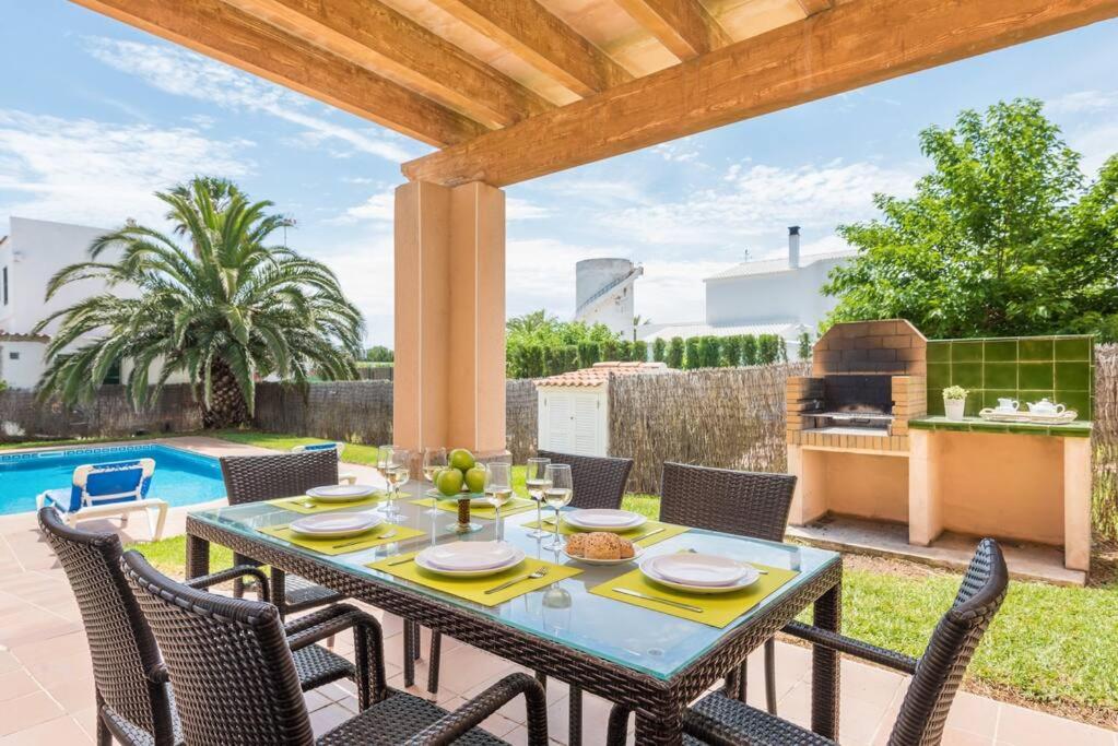 patio ze stołem, krzesłami i sprzętem do grillowania w obiekcie Villa Judith En Menorca w mieście Son Carrio