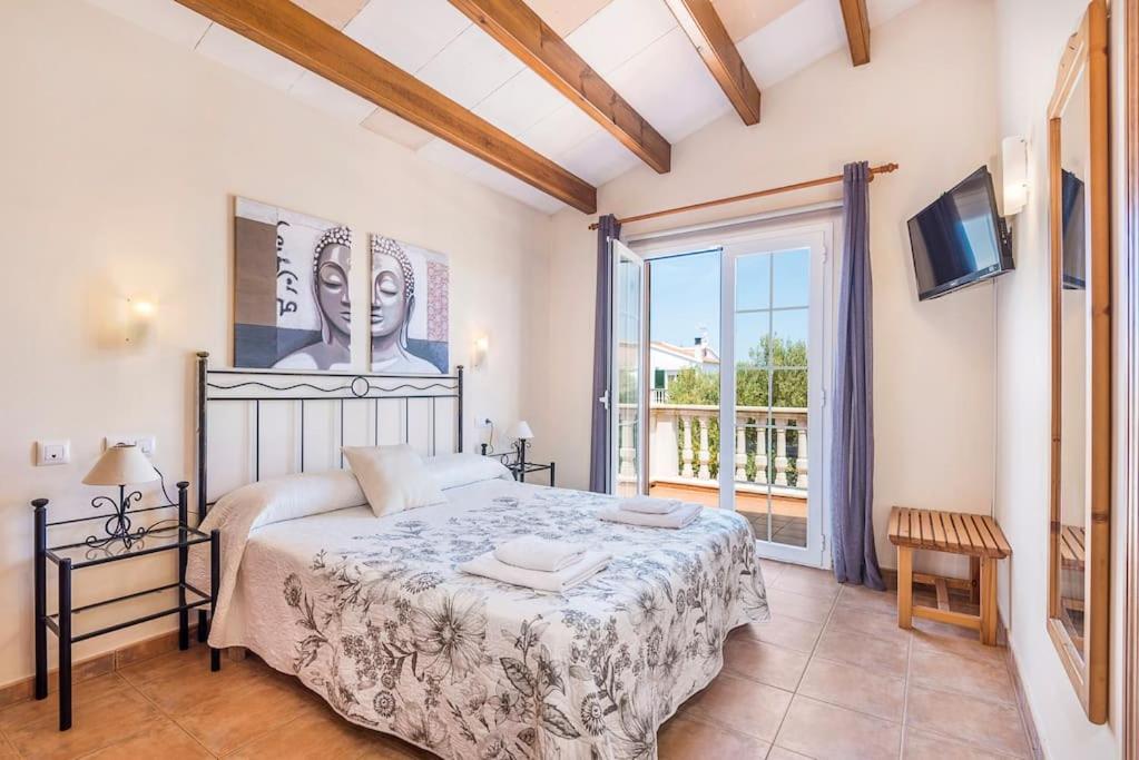 sypialnia z łóżkiem i dużym oknem w obiekcie Villa Judith En Menorca w mieście Son Carrio