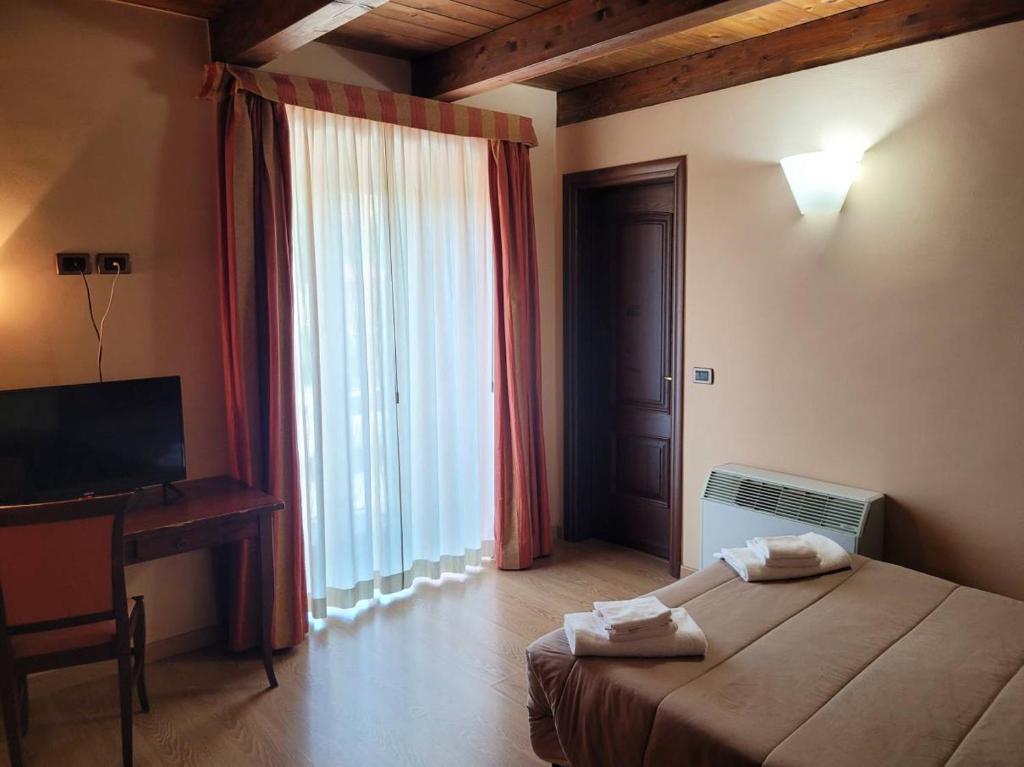 a bedroom with a bed and a desk and a window at Locanda San Pietro in Preturo