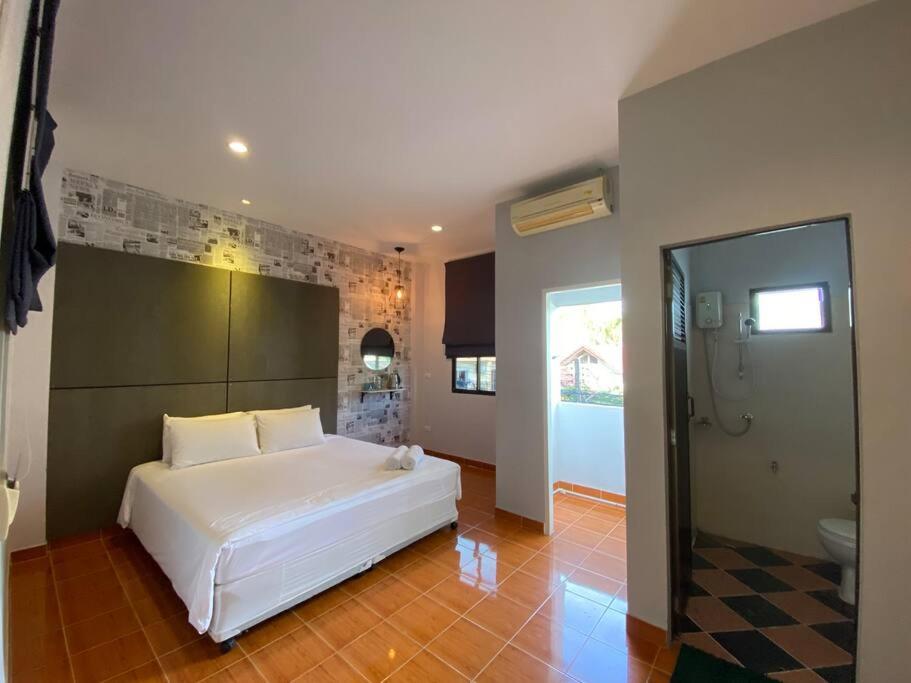 1 dormitorio con cama blanca y baño en Chernin hotel & Spa, en Ban Bang Chak
