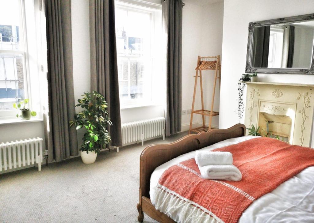 a bedroom with a bed with two towels on it at Luminous Town house by the sea in Kent