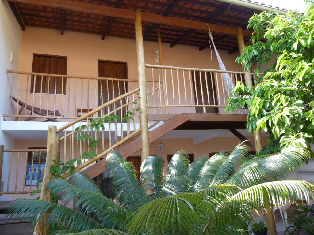 a building with a wooden staircase and palm trees at Pousada Casa de Nomades in Vale do Capao
