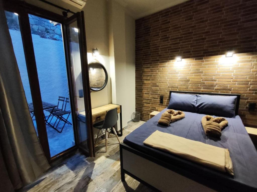 a bedroom with a bed and a large window at Grecos STAY SKIATHOS in Skiathos Town