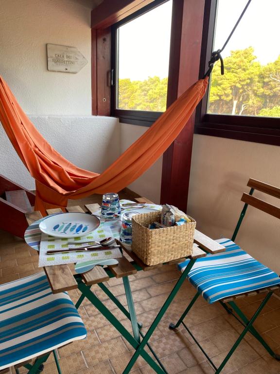 a hammock in a room with two chairs and a table at B&b da Tizzy in San Domino