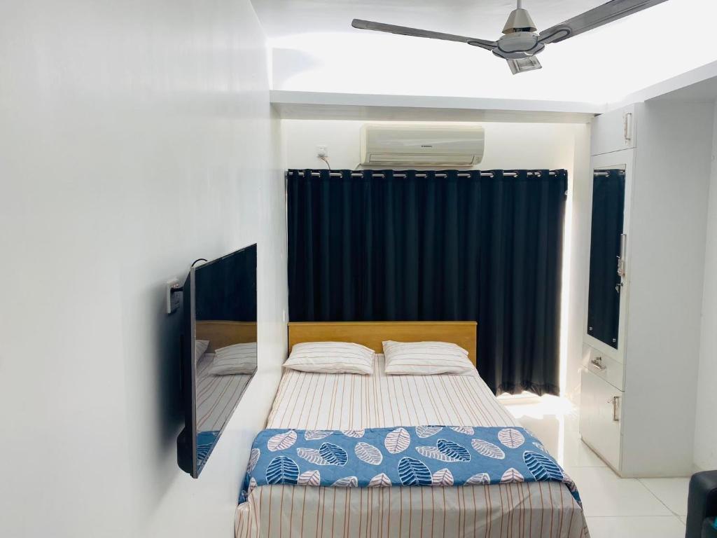 een slaapkamer met een bed en een blauw gordijn bij Studio apartment nearby Dhaka airport in Dhaka