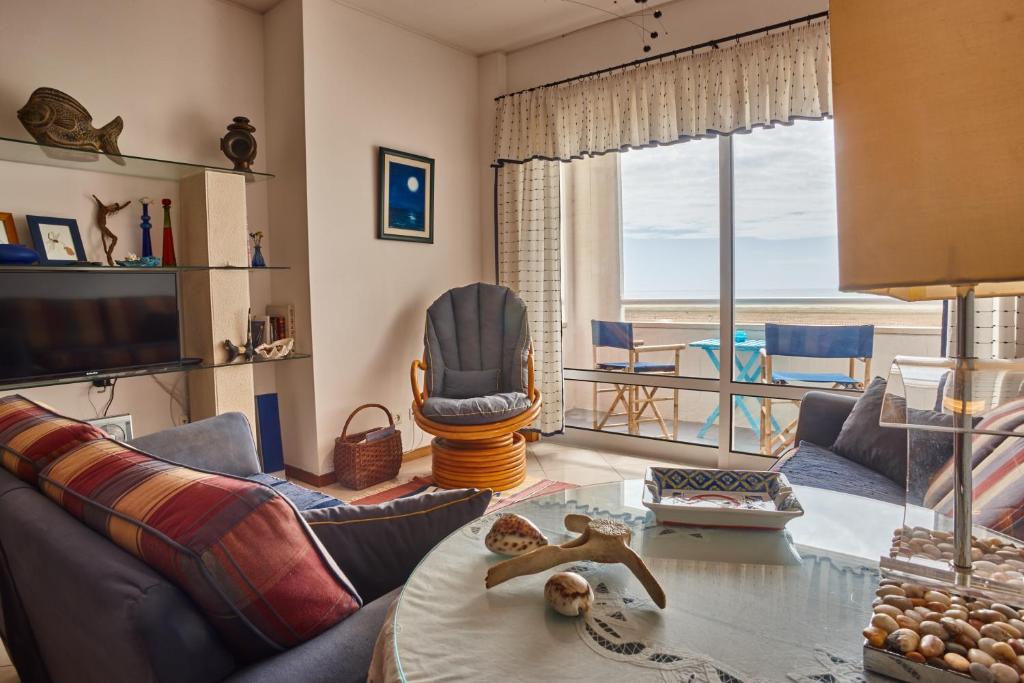a living room with a couch and a view of the ocean at Varandas do Oásis in Figueira da Foz
