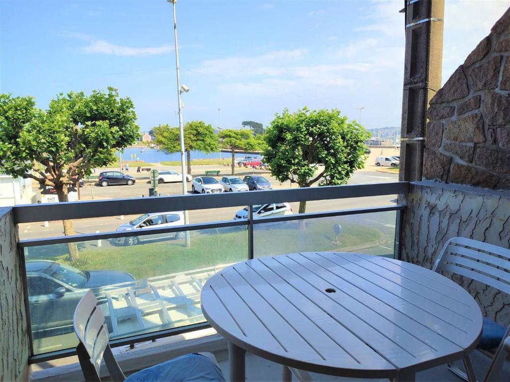 d'une table et de chaises sur un balcon avec vue sur la rue. dans l'établissement Appartement avec WIFI, parking, balcon-terrasse et ascenseur à Perros-Guirec - FR-1-368-354, à Perros-Guirec