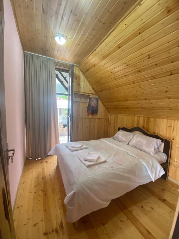 una camera con un grande letto in un soffitto in legno di Kirta a Bangveti