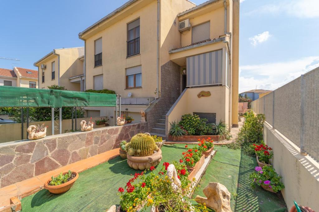 a house with a garden with potted plants and flowers at domo nora in Olbia