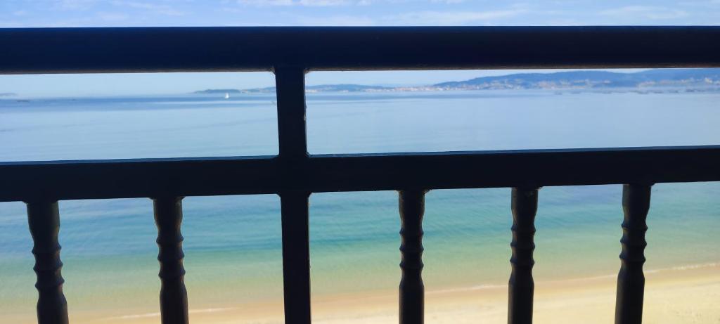 a view of the beach and ocean from a window at Alojamiento en Bueu (Loureiro) in Bueu