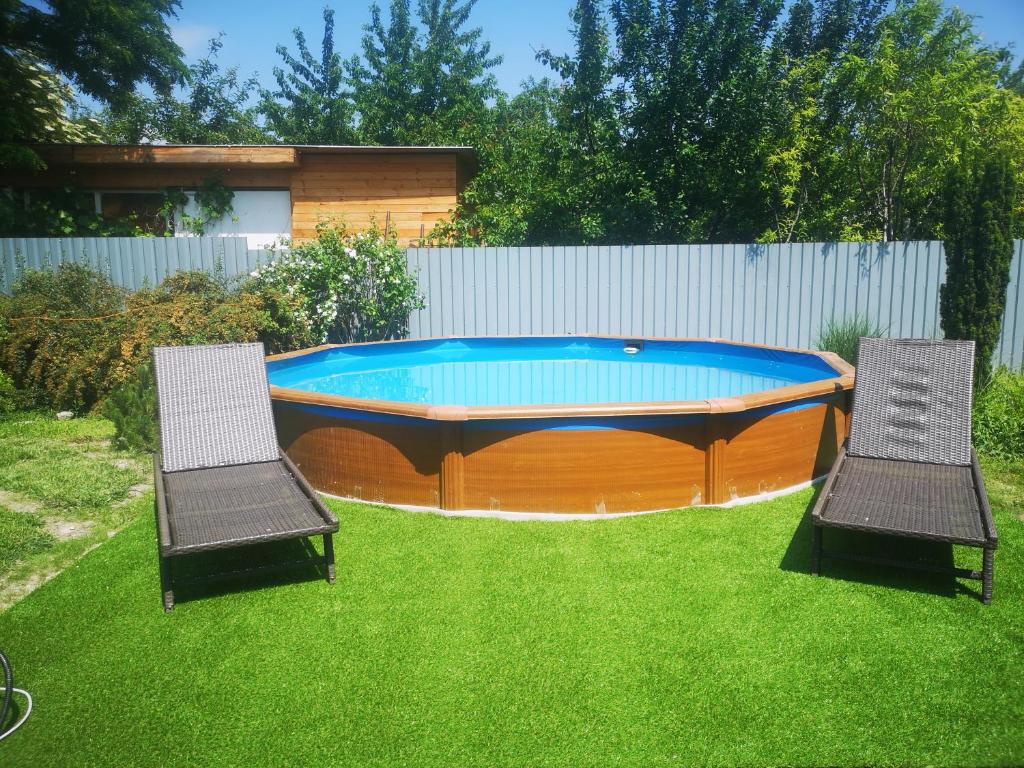 two chairs and a swimming pool in a yard at Gere House in Siófok