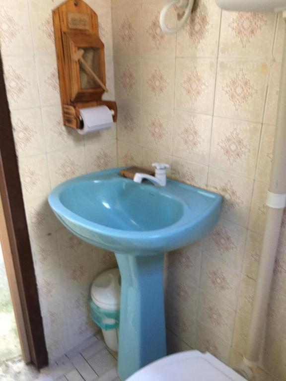 y baño con lavabo azul y aseo. en Saquarema hospedagem en Saquarema