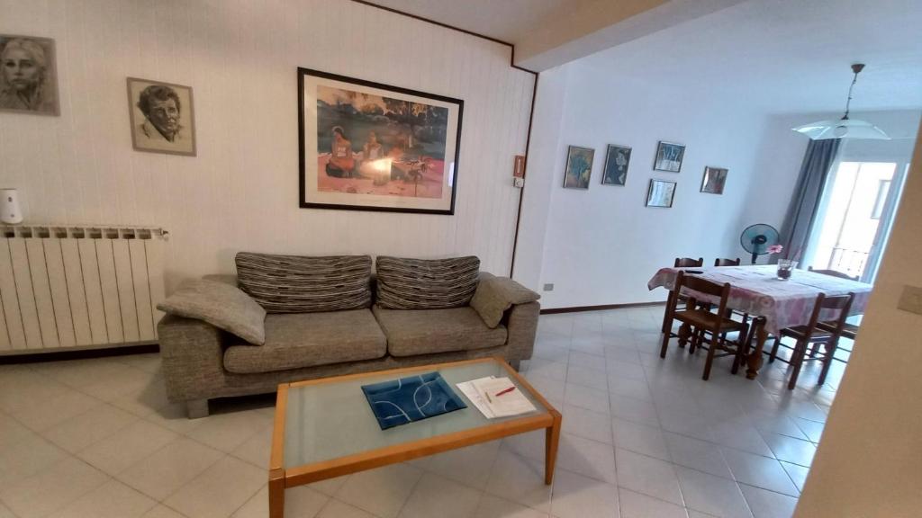 ein Wohnzimmer mit einem Sofa und einem Tisch in der Unterkunft Casa Martina "holiday home" Marano Lagunare in Marano Lagunare