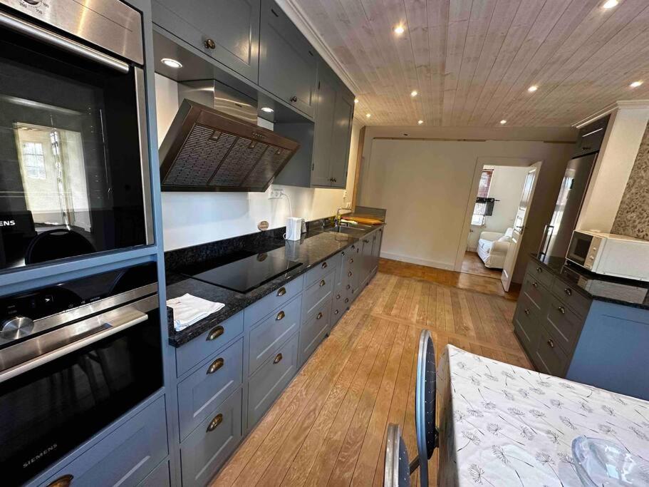 a large kitchen with stainless steel appliances and wooden floors at Östavall Kölsillre Lyxvilla, fiber internet WiFi in Haverö