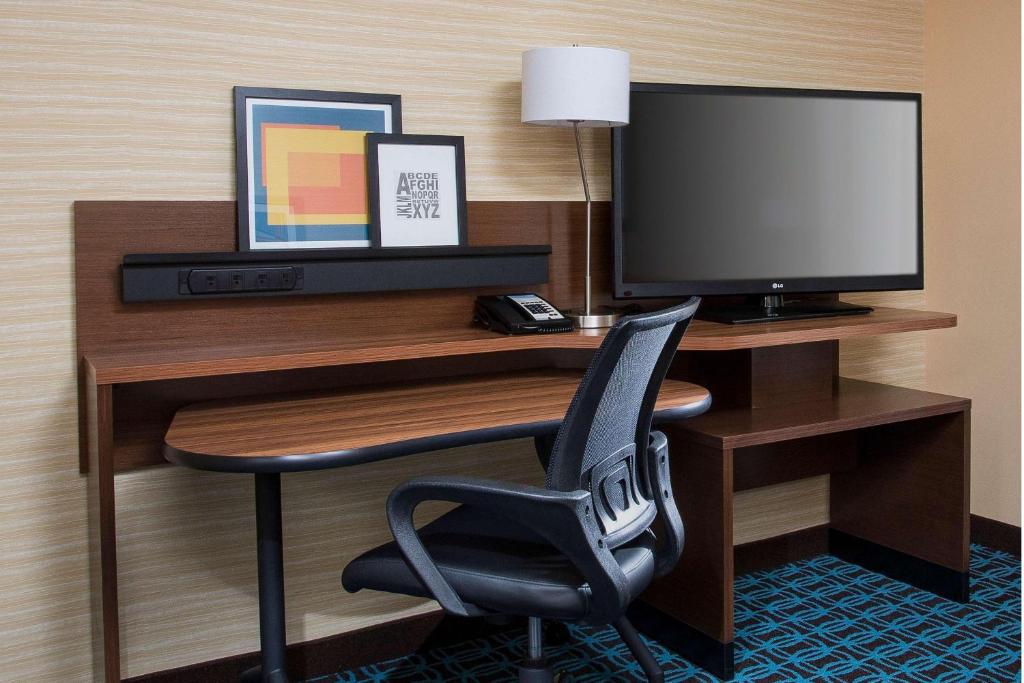 Fairfield Inn & Suites By Marriott Sioux Falls Airport في شلالات سيوكس: مكتب مع جهاز كمبيوتر وكرسي في الغرفة