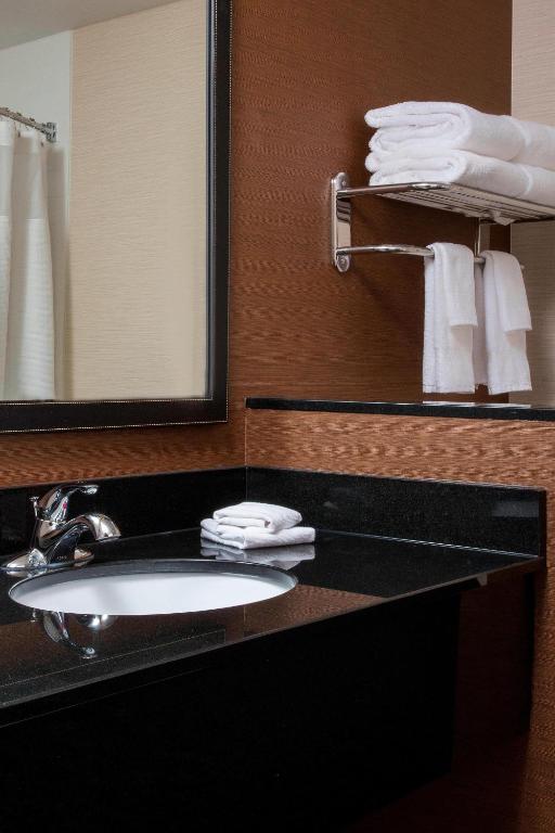 uma casa de banho com lavatório, espelho e toalhas em Fairfield Inn & Suites By Marriott Sioux Falls Airport em Sioux Falls