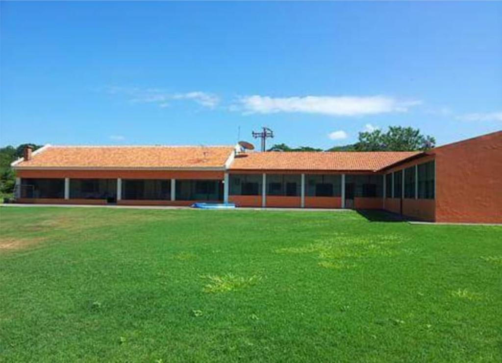 a large building with a green field in front of it at Pousada Navegantes in Pôrto Albuquerque