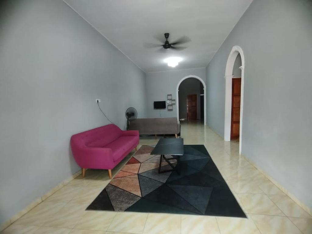 峇株巴辖DAHLIA HOMESTAY Batu Pahat的客厅配有粉红色的沙发和桌子