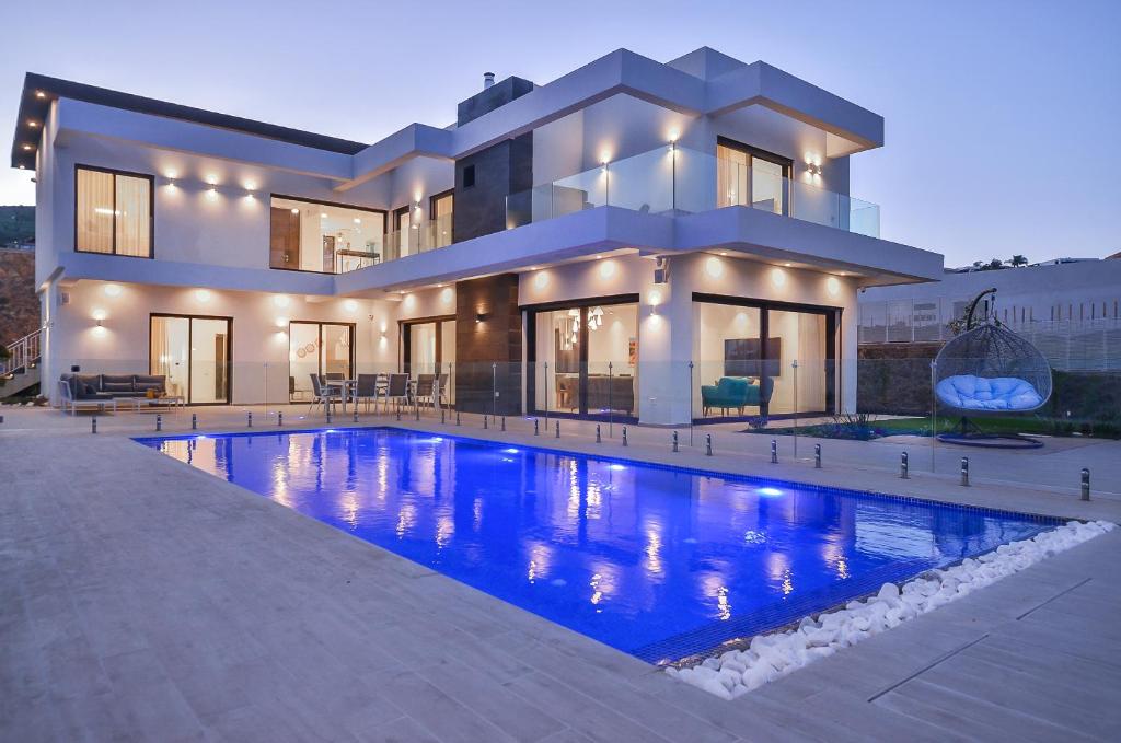 a large house with a swimming pool in front of it at פרימור סוויטות יוקרה Primor Deluxe Suits in Kinneret