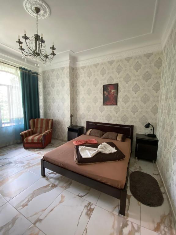 a bedroom with a bed and a chair at Апартаменти в парку in Uman