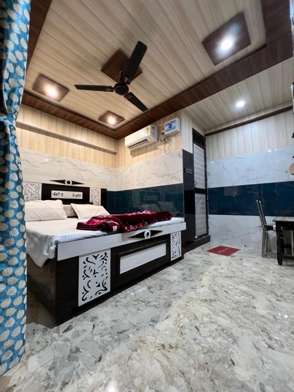 een slaapkamer met een bed en een plafondventilator bij Hotel Raghunandan Near Shree Ram Janambhumi in Ayodhya