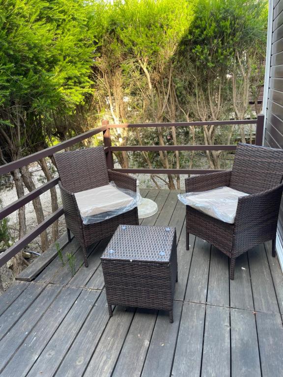 two chairs and a table on a deck at Quinta Dos Amarelos no Meco in Aldeia do Meco
