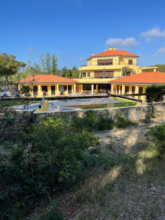 a building with a pool in front of it at Quinta Dos Amarelos no Meco in Aldeia do Meco