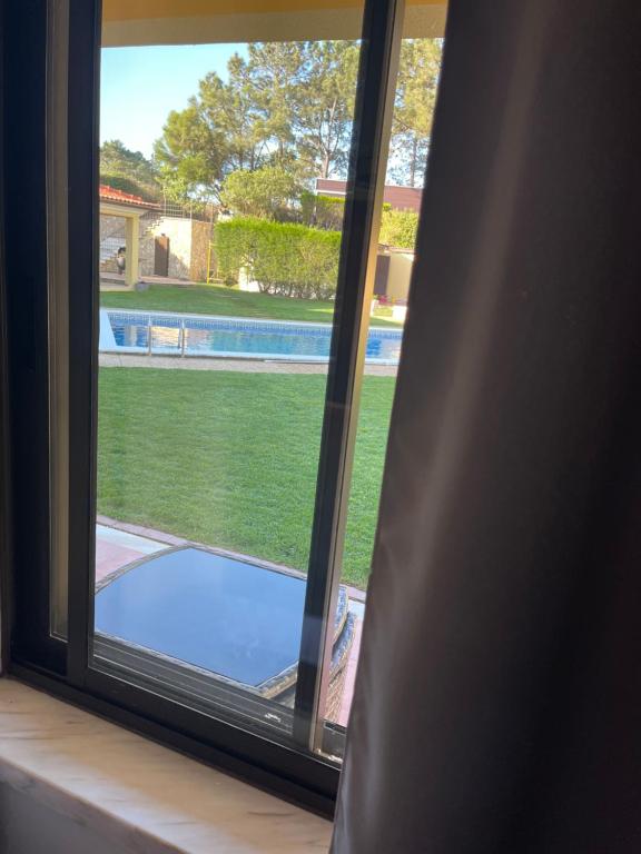 a view of a swimming pool from a window at Quinta Dos Amarelos no Meco in Aldeia do Meco