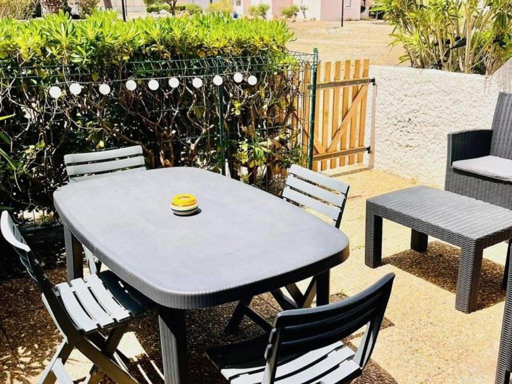 d'une table et de chaises avec une tasse. dans l'établissement Appartement T2 avec grande terrasse, parking, animaux admis et piscine - FR-1-195-94, au Barcarès