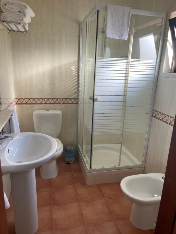 a bathroom with a shower and a sink and a toilet at Quinta Dos Amarelos no Meco in Aldeia do Meco