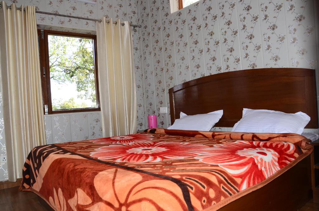 a bedroom with a large bed with a floral bedspread at Bhandari Homestay and Restaurant in Mussoorie