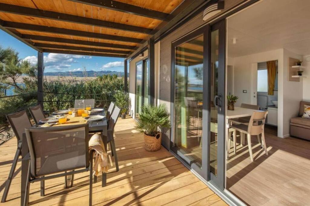 a patio with a table and chairs on a deck at Lavanda Mobile Home at Terra Park Spiritos camp in Kolan