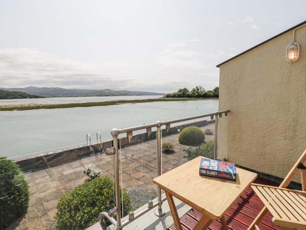 a balcony with a table and a view of a river at 25 South Snowdon Wharf in Porthmadog