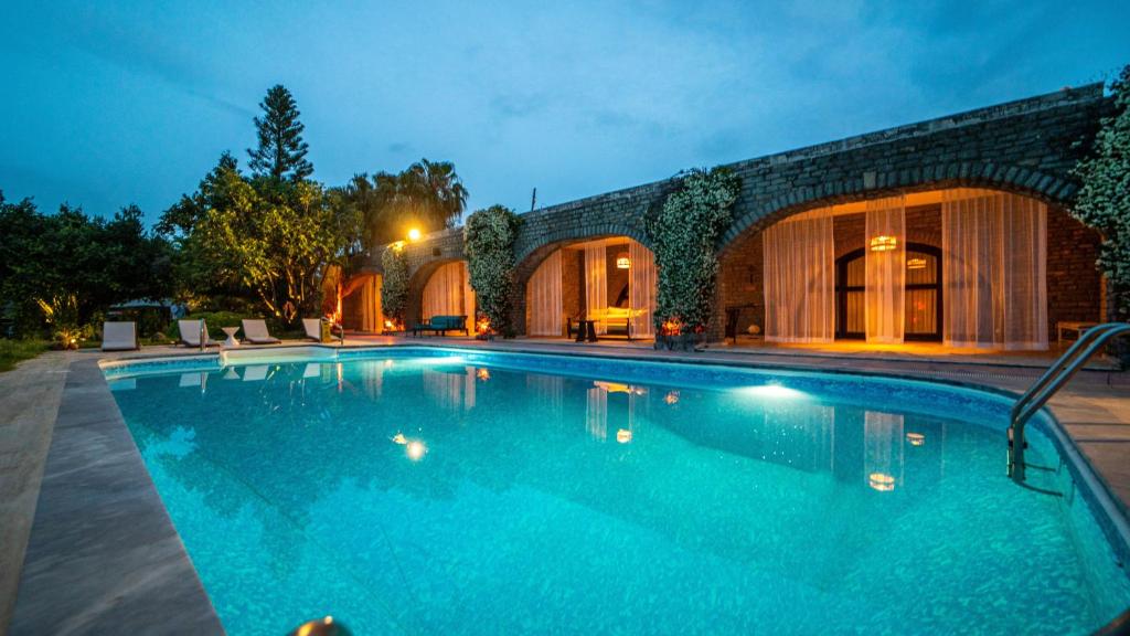 a swimming pool in front of a building at night at Almina Garden Boutique in Bodrum City