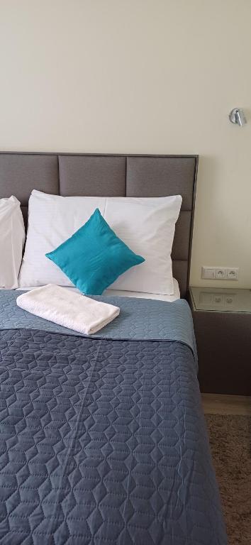 uma cama com almofadas azuis e brancas em garni Hotel S.O.G.* * * em Trenčín