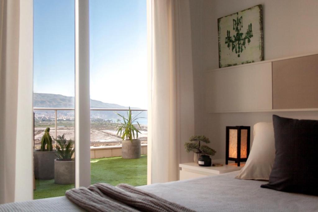 Schlafzimmer mit einem Bett und einem großen Glasfenster in der Unterkunft MAR y SAL in Roquetas de Mar