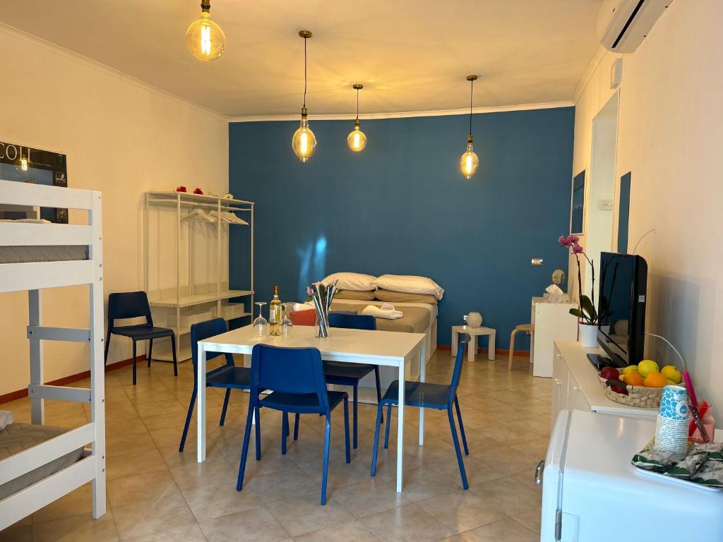 une salle à manger avec une table blanche et des murs bleus dans l'établissement Amarcord, à Pouzzoles