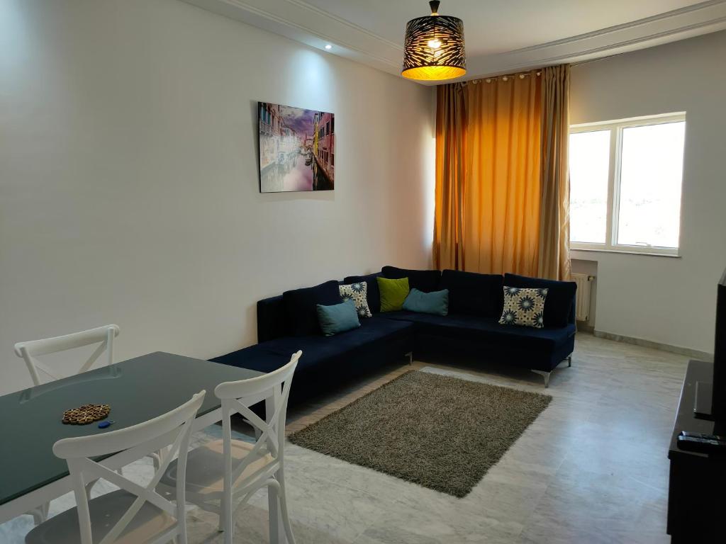 - un salon avec un canapé bleu et une table dans l'établissement luxury family apartment in ain Zaghouan nord, à El Aouina