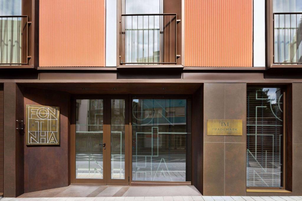 a building with doors and windows with a sign on it at Fontinha Porto, Trademark Collection by Wyndham in Porto