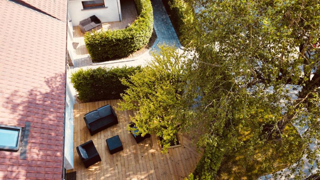een uitzicht over de tuin met stoelen en bomen bij Gîtes L'Ancienne Ecurie - L'Ancien Atelier in Saint-Quentin-en-Tourmont